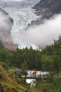 Tourists on the bridge over the stream at Briksdal glacier Royalty Free Stock Photo