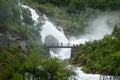 Tourists on the bridge and waterfall splashes shower Royalty Free Stock Photo