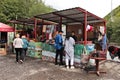 Tourists buying some Georgian food from a road side shop next to the black and white Aragvi river