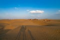 Tourists with camels, Camelus dromedarius, at sand dunes of Thar desert, Rajasthan, India. Camel riding is a favourite activity Royalty Free Stock Photo