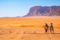 Tourists on camels crossing wadi rum desert in Jordan