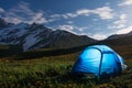 Tourists camp in mountains at night. Hikers tent in night mountain valley