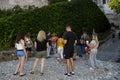 Tourists carefully listen to the guide on the territory of the old castle on the shore of Lake