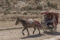 Tourists in the cart with horses. The road to Petra, to Al Khazneh, the Treasury. Petra, a historical and archaeological city in