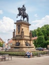 Tourists check map bellow statue of King George