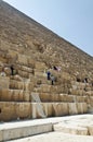 Tourists clamberig on the ruined wall of an Egyptian pyramid Royalty Free Stock Photo