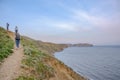 Tourists climb a mountain against the background of the Cape Chameleon and Black Sea bay in the Crimean Peninsula