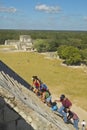 Tourists climbing the Mayan Pyramid of Kukulkan (also known as El Castillo) and ruins at Chichen Itza, Yucatan Peninsula, Mexico