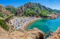 Tourists colorful sun umbrellas at Costa Paradiso Beach, Sardinia, Italy