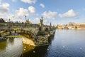 Tourists cross the Charles Bridge in Prague, Czechia with St Vitus cathedral and the Prague castle in the distance