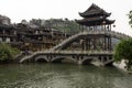 Tourists cross the Nanhua Bridge over the Tuo Jiang River to see more of Fenghuang Ancient City in Tibet, China