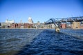 Tourists crossing the River Thames by walking through Millennium Bridge with Saint Paul`s Cathedral in background, London, UK Royalty Free Stock Photo