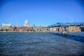 Tourists crossing the River Thames by walking through Millennium Bridge with Saint Paul`s Cathedral in background, London, UK Royalty Free Stock Photo