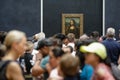 Tourists crowd to take photos of the famous Mona Lisa painting of Leonardo da Vinci inside the Louvre museum