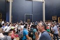 Tourists crowd to take photos of the famous Mona Lisa painting of Leonardo da Vinci inside the Louvre museum