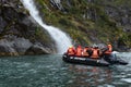 Tourists from the cruise ship near the waterfalls of the glacier Nena. Royalty Free Stock Photo