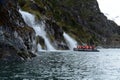 Tourists from the cruise ship near the waterfalls of the glacier Nena. Royalty Free Stock Photo