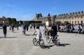 Tourists cycle at the Louvre museum in Paris, France Royalty Free Stock Photo