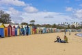 Tourists at Dendy Street Beach, Brighton with colourful bathing houses in Melbourne