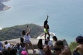 Tourists of different nationalities in line to take the picture on the rock.