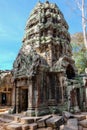 Tourists are drawn to the aged charm of the crumbling stone tower at Ta Prohm, a testament to ancient Khmer architectural prowess