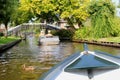 Tourists driving electric boat canal, Giethoorn, Netherlands