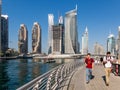Tourists walking Dubai Marina Walk promenade