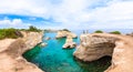 Tourists on the edge of rock. Torre Sant Andrea beach with its soft calcareous rocks and cliffs, sea stacks, small coves and the