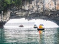 Tourists enjoy bamboo boating around the Luon cave, Bo Hon island in Vietnam, on a rainy day