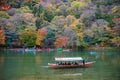 Tourists enjoy crusing in the Hozu river at Arashiyama during beautiful autumn season.