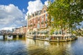 Tourists enjoy a relaxing waterfront lunch at a hotel on one of the major canals near the Museum District in Amsterdam Netherlands