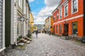 Tourists enjoy sightseeing and shopping on one of the cobblestone streets in the colorful, medieval town of Porvoo, Finland