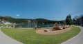 Tourists enjoy summer activities on the lakeshore in Arosa with the train and cable railway station in the background Royalty Free Stock Photo