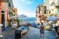 Tourists enjoy a sunny day on the Ligurian coast with the sea, cafe and boats in Riomaggiore Italy, on the Cinque Terre