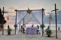 Tourists enjoy the sunset view on the beach. On the sand set table decorated for a romantic dinner. Against the background of the Royalty Free Stock Photo