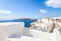 Tourists enjoy the upper walkway in Oia, Greece, on a busy summer day overlooking the Aegean Sea on the island of Santorini Royalty Free Stock Photo