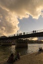 Tourists enjoy the warmth of spring, on a bridge of the Seine river in Paris.