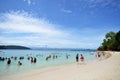 Tourists enjoy white sand beach of Sapi island in Sabah