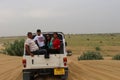 Tourists enjoying adventurous open jeep safari in Jaisalmer desert camp Royalty Free Stock Photo