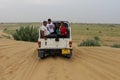 Tourists enjoying adventurous open jeep safari in Jaisalmer desert camp Royalty Free Stock Photo