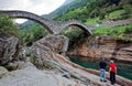 Tourists enjoying the beautiful scenery of the famous Double Arch stone bridge