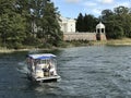 Tourists are enjoying boat trip to sightseeing Uzutrakis Manor that located on the shore of Lake Galve in Trakai, Lithuania.