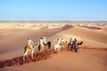 Tourists enjoying with camel caravan in the Sahara desert. Merzouga, Morocco.