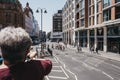 Tourists enjoying city views from top deck of of tour bus in London, UK, on a bright summer day Royalty Free Stock Photo