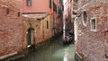 Tourists enjoying gondola ride through the narrow canals in Venice