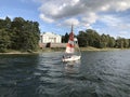Tourists are enjoying sail boat to sightseeing Uzutrakis Manor that located on the shore of Lake Galve in Trakai, Lithuania.