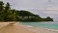 Tourists enjoying their holidays on tropical beach in Baie Lazare, Mahe, Seychelles with turquoise water and coconut trees Royalty Free Stock Photo