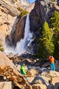 Tourists enjoying view of frosty Lowe Yosemite Falls in early spring