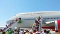 Tourists enter a large plane, use two ladders return from vacation