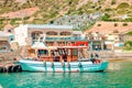 Tourists excursion boat anchored off Spinalonga island in the Mediterranean Sea